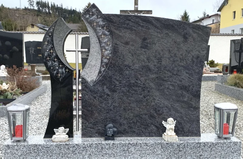 Individuell gestaltete Grabanlage aus Naturstein, gefertigt vom Steinmetz in Zwettl. Der Doppelgrabstein aus Silk Blue Granit wird durch ein Aluminium-Kreuz und passende Laternen ergänzt. Das Grabdenkmal ist von einer eleganten Tarn Granit-Einfassung umgeben.