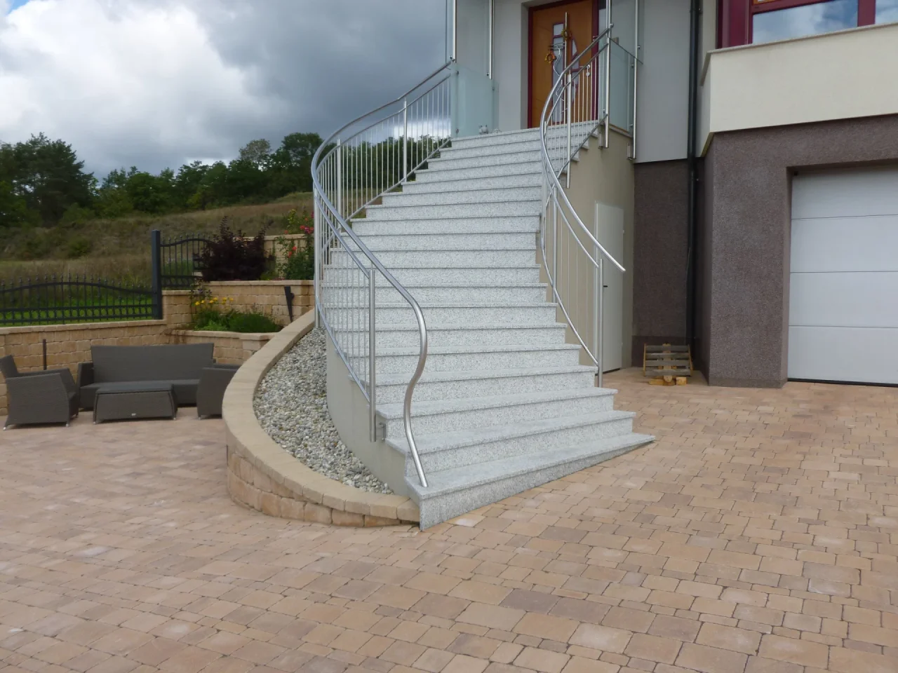 Maßgefertigte, geschwungene Außentreppe aus Granit. Eine langlebige Steinmetz-Arbeit für den Eingangsbereich in Niederösterreich.