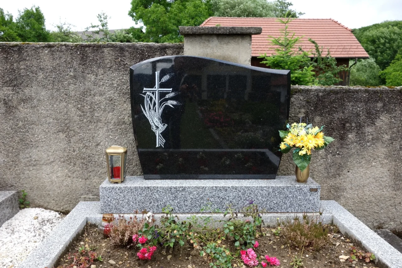 Ein individuelles Doppelgrab aus Impala Naturstein mit einer Tarn-Einfassung. Dieses Grabmal, gefertigt von unserem Steinmetz in Krems, wird durch stilvollen Grabschmuck aus Bronze ergänzt.