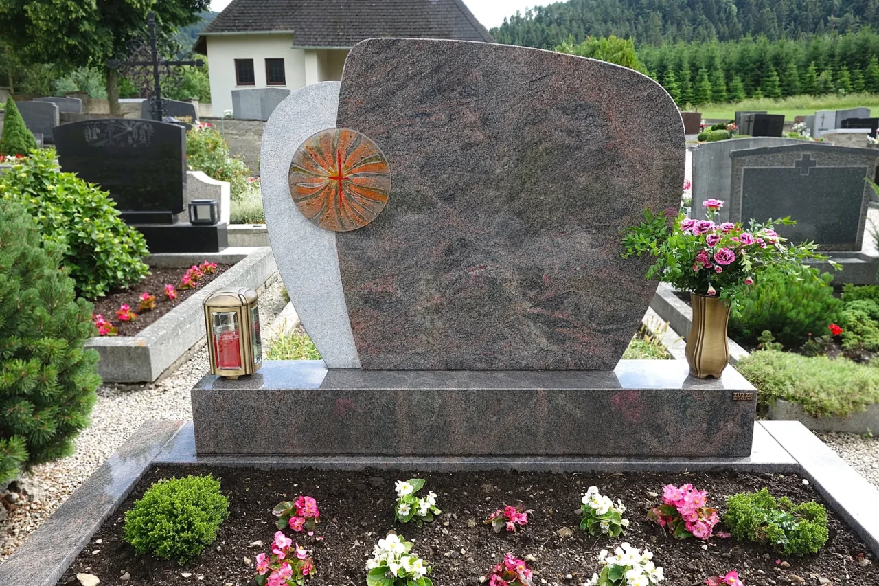 Ein individueller Doppelgrabstein mit einem persönlichen Ornament, gefertigt von unserem Steinmetz in Krems. Dieses Grabmal aus Naturstein spiegelt die gemeinsame Geschichte wider.