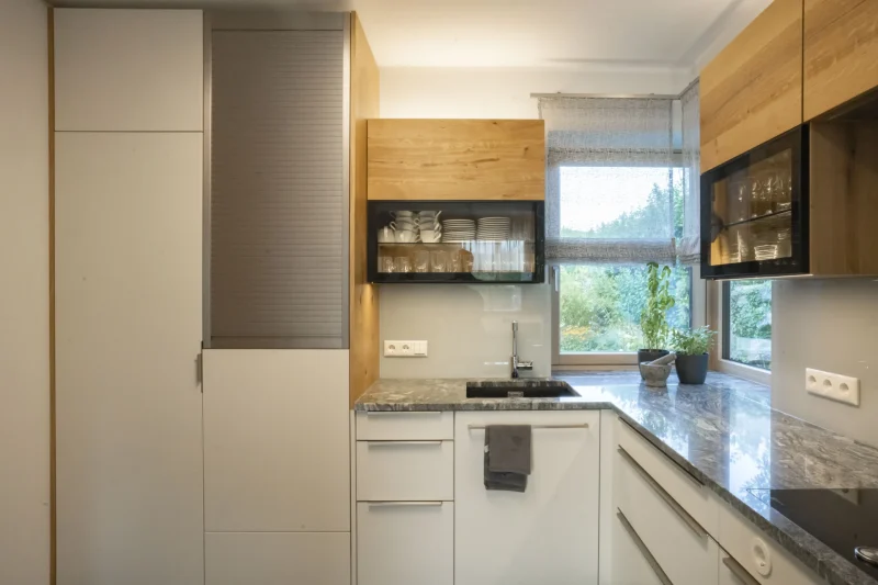 Nahaufnahme einer Spüle, perfekt in eine Küchenarbeitsplatte aus grünem Naturstein integriert. Präzise Steinmetz-Arbeit aus der Region Krems, die jedes Detail perfektioniert.