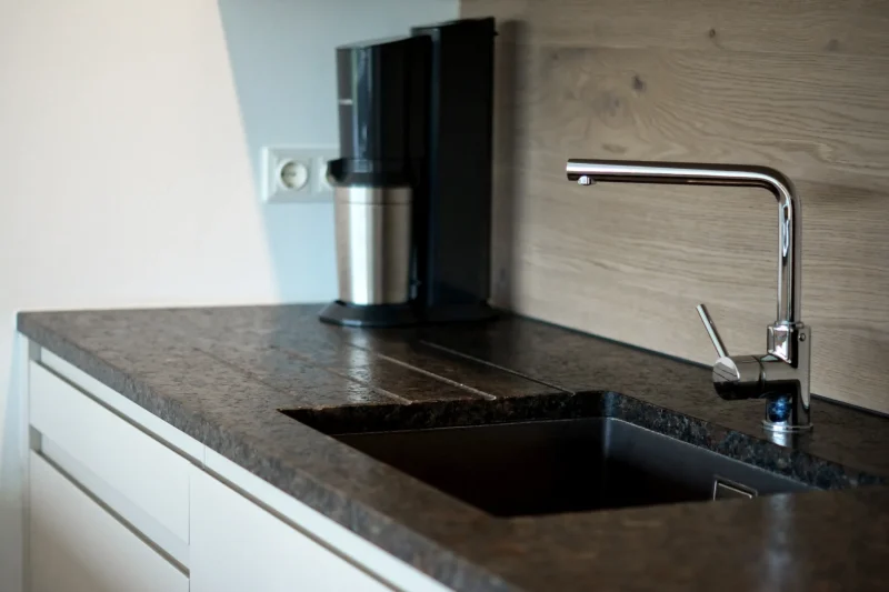 Spülbereich aus Coffee Brown Granit mit integriertem Abtropfbecken. Eine professionelle und funktionale Naturstein-Lösung, gefertigt vom Steinmetz in Krems.