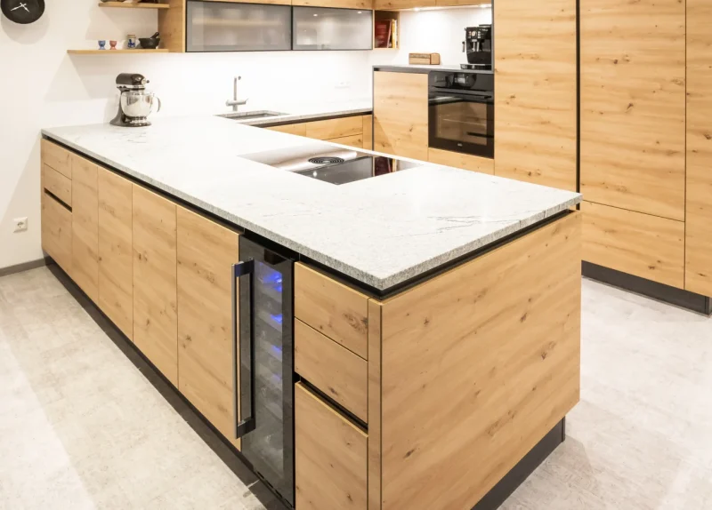 Kücheninsel aus poliertem Granit mit integriertem Weinkühlschrank. Eine hochwertige Naturstein-Lösung, die Funktionalität und Luxus vereint. Vom Steinmetz in Niederösterreich.