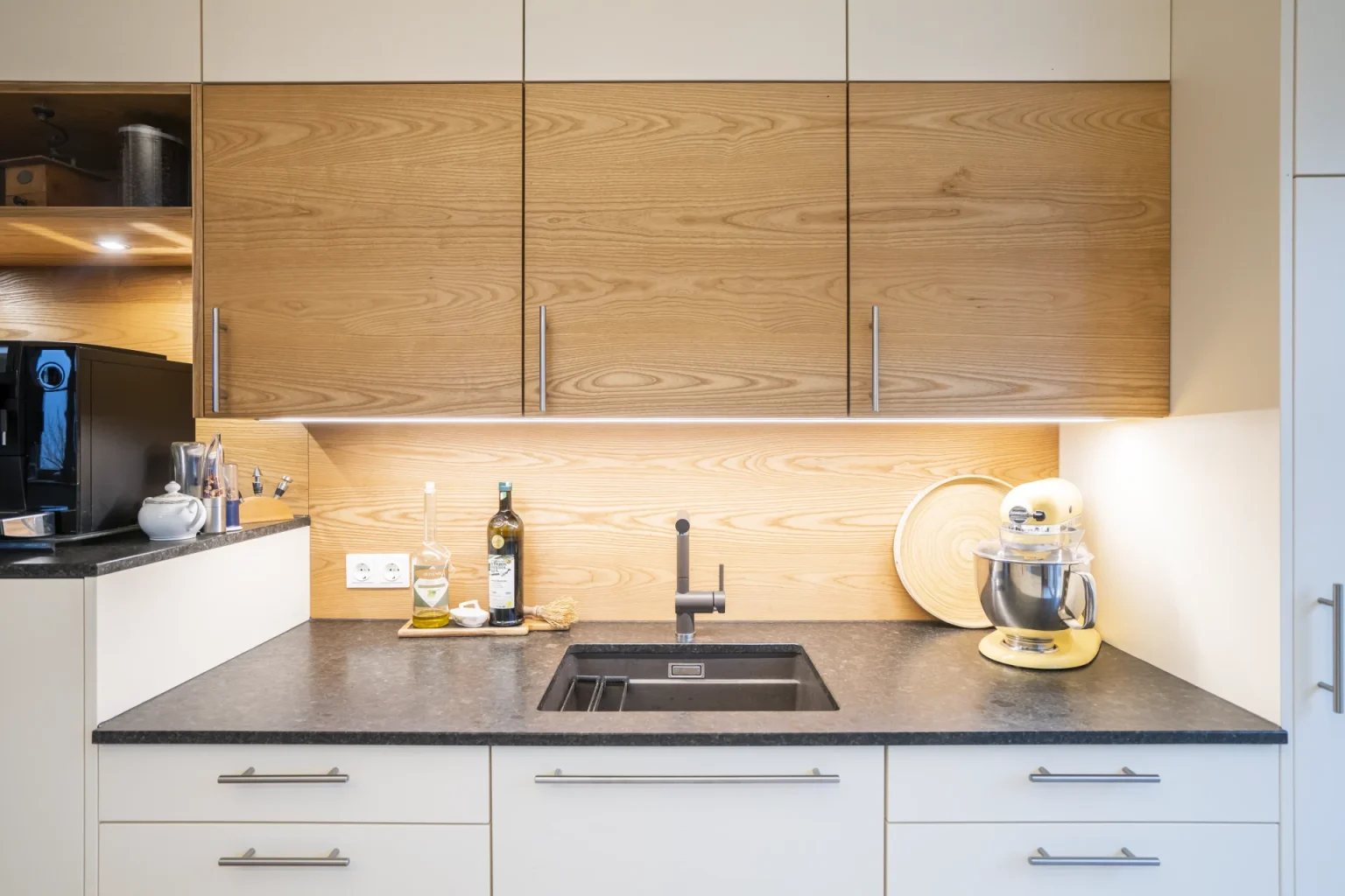 Partnerfirmen 2 Nahaufnahme einer Spüle, perfekt eingelassen in eine Küchenarbeitsplatte aus poliertem Coffee Brown Granit. Präzise Steinmetz-Arbeit in Niederösterreich.