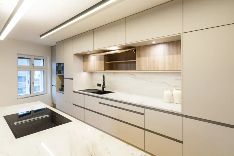 Detailansicht einer Kochinsel und Spüle mit einer Küchenarbeitsplatte aus weißem poliertem Granit. Gefertigt von einem Steinmetz in Niederösterreich.