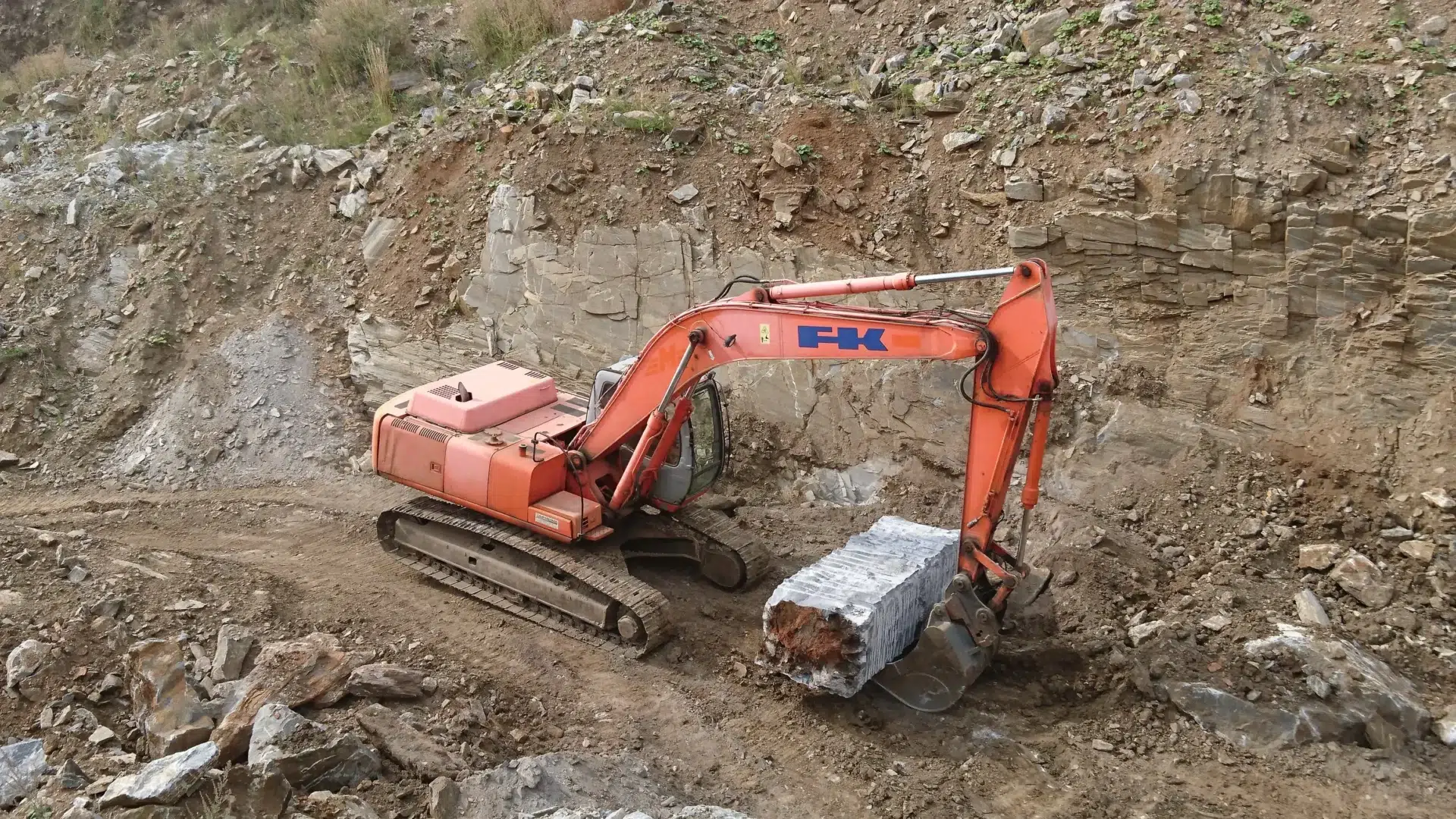Ein Bagger transportiert einen 20-Tonnen-Rohblock aus Wachauer Marmor in unserem Steinbruch in Niederösterreich.