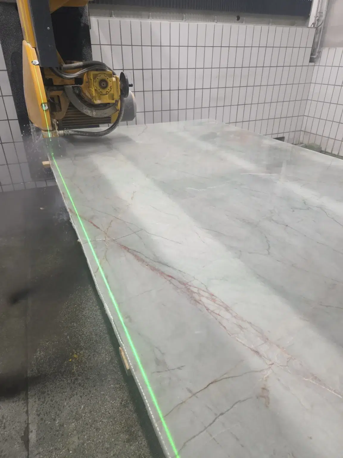 Partnerfirmen 6 Steinmetz Zuzzi schneidet eine Emerald Greeen Jardore Quarzit Platte mit der Brückensäge zu einer Individuellen Küchenarbeitsplatte aus Naturstein.